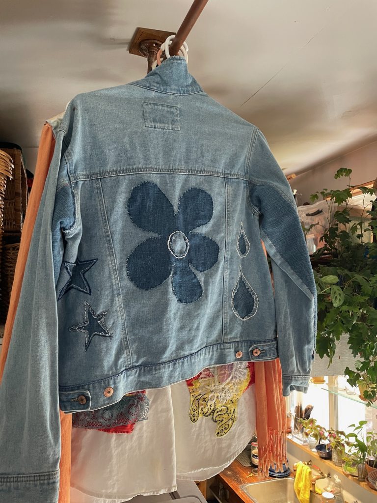 Denim jacket back with sashiko flower and raindrop stitching.