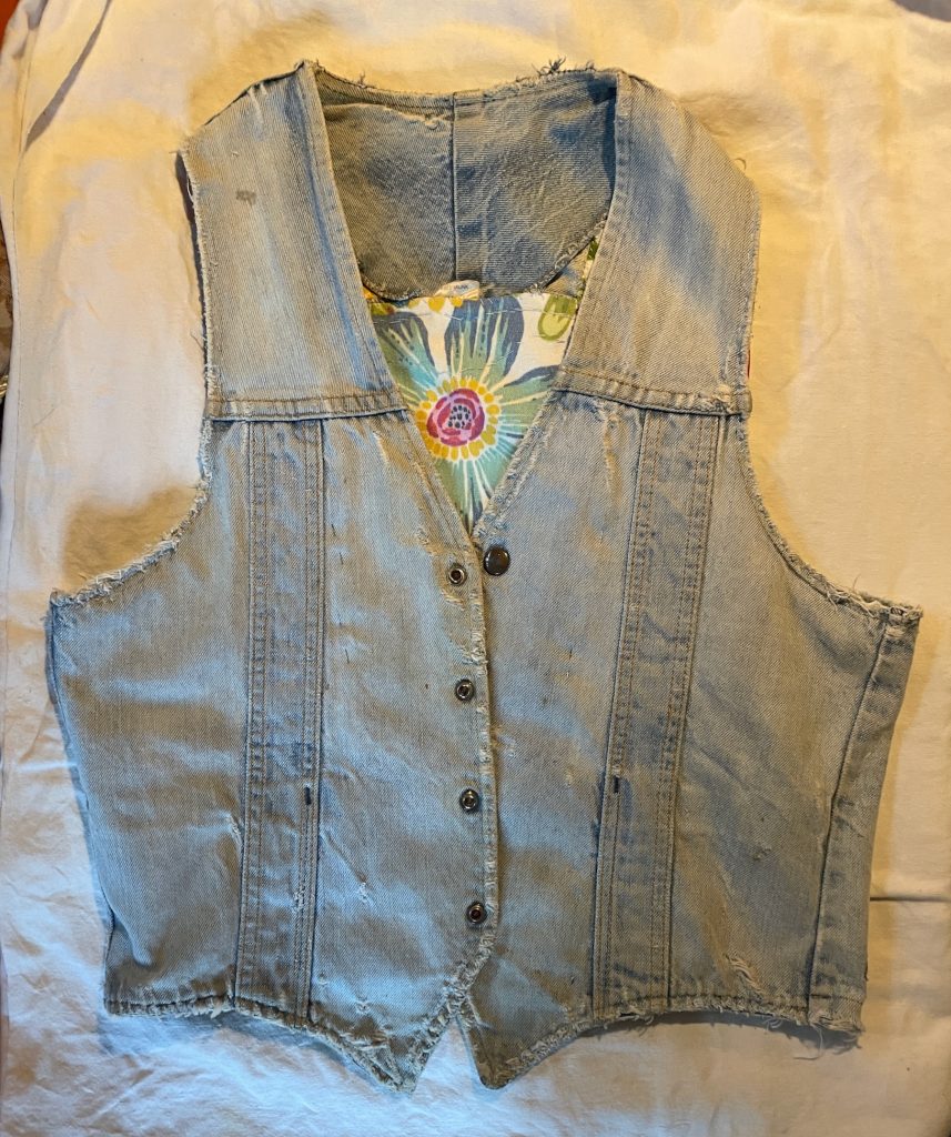 Up-cycled denim vest front with frayed seams and floral lining.