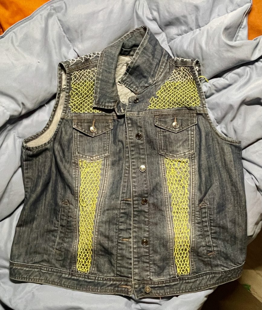 Up-cycled denim vest with yellow sashiko stitching on front.